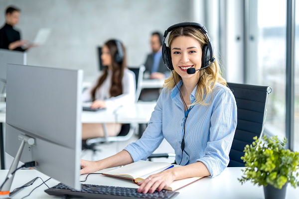 Mitarbeiterin im Beratungsgespräch mit Headset am Arbeitsplatz