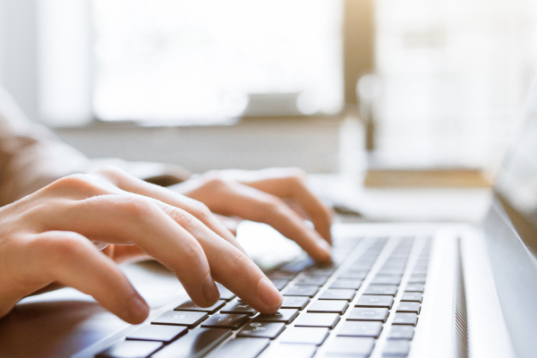 Mitarbeiter beim Verfassen einer E-Mail am Laptop